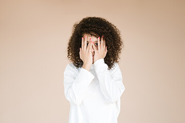 Portrait of anxious scared young african american girl isolated over beige background. Negative emotions, human reaction, expression      