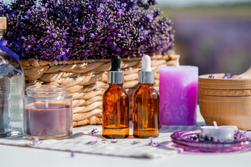 Fototapeta na wymiar Dropper bottle with lavender cosmetic oil or hydrolate against lavender flowers field as background with copy space. Herbal cosmetics and modern apothecary concept