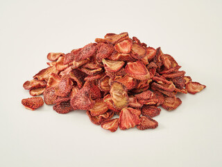 Fresh many strawberry dried fruit on the white background, in the wooden cup.