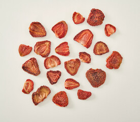 Fresh many strawberry dried fruit on the white background, in the wooden cup.