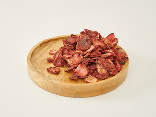 Fresh many strawberry dried fruit on the white background, in the wooden cup.