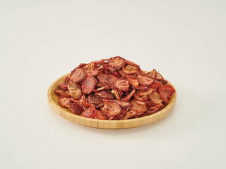 Fresh many strawberry dried fruit on the white background, in the wooden cup.