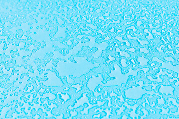 Water drops condensate on blue background texture on transparent glass. backdrop glass covered with abstract drops of water.