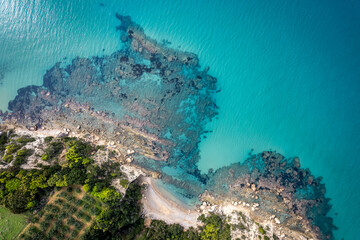 paesaggio di fondale marino roccioso e di sabbia visto dall'alto con drone con mare trasparente...