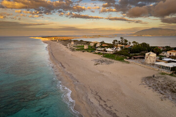 paesaggio spiaggia con mulino a vento vista dall'alto, scattata al tramonto con nuvole con drone a...
