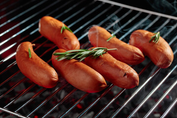 Grilled sausages with rosemary on a grill.