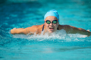 Fototapeta na wymiar Young woman swimming butterfly stroke