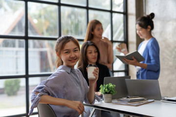 Beautiful young Asian businesswomen are meeting in the office to plan marketing and planning a new system. Looking at camera.
