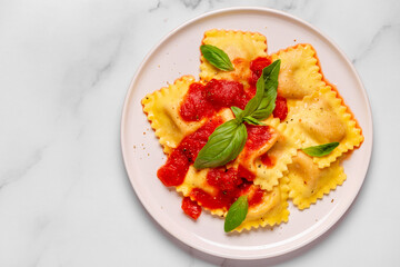 Delicious appetizing ravioli with tomato sauce and basil