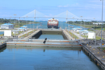 Several freighters, assisted by tugboats, are entering the Panama Canal at Gatun Locks on the...