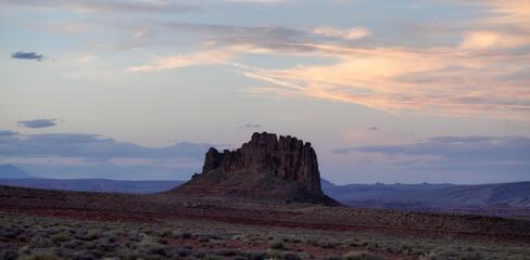 Red Rock Mountain Landscape during colorful sunset sky. Alhambra Rock near Mexican Hat, Utah, United States. American Nature Background