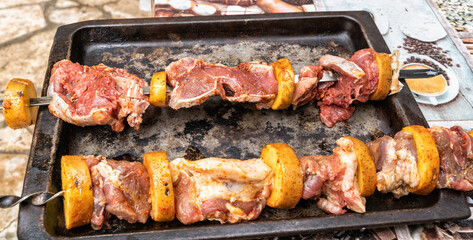 Raw meat for shish kebab and potatoes strung on a skewer for cooking in a traditional Turkish and Caucasian tandoor