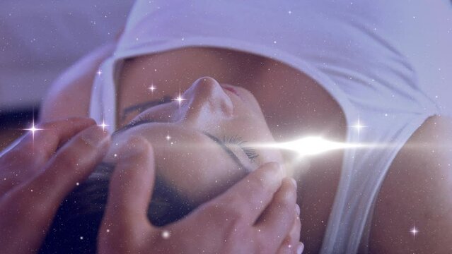 Animation of stars moving over hands of caucasian man doing massage to female customer