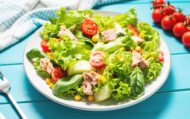 Tuna Fish Salad with Lettuce, Cherry Tomatoes, Cucumber and Corn on wooden background