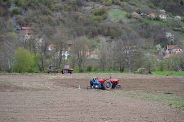 people with tractors in the field in spring