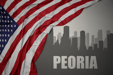 abstract silhouette of the city with text Peoria near waving colorful national flag of united states of america on a gray background.