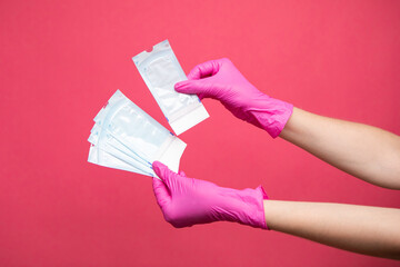 Hand holding sterilization envelopes for manicure in gloves