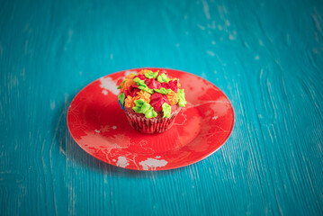 Delicious organic homemade cupcake on a colorful ceramic plate.