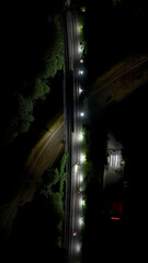 Obraz premium Railway workers at night in lights repairing track aerial view