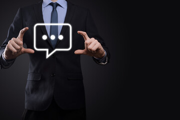 Businessman holding a message icon, bubble talk notification sign in his hands. Chat icon, sms icon, comments icon, speech bubbles