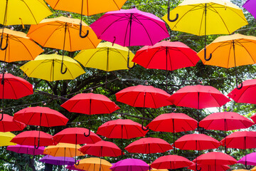 Fototapeta na wymiar Street decorated with colorful umbrella. Runner of colorful umbrellas.