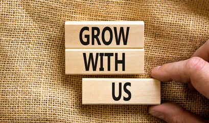 Grow with us symbol. Concept words Grow with us on wooden blocks on a beautiful canvas table canvas background. Businessman hand. Business, motivational and grow with us concept. Copy space.