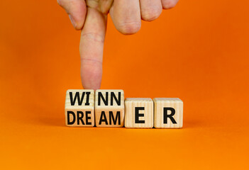 Winner or dreamer symbol. Concept words Winner or dreamer on wooden cubes. Businessman hand. Beautiful orange table orange background. Business and Winner or dreamer concept. Copy space.