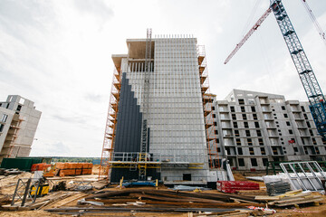 scaffolding at construction site with cranes and machinery for builders