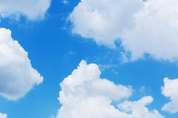 Naklejka na ściany i meble A large white fluffy cloud against a blue sky. The cloud occupies the bottom of the photo