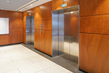Two elevator doors in office building. Wide angle view of modern wood elevators with doors. Elevators in the modern wood lobby house or hotel