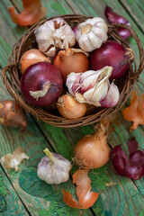Onions and garlic in a wicker basket on an old background. Rustic, vintage style