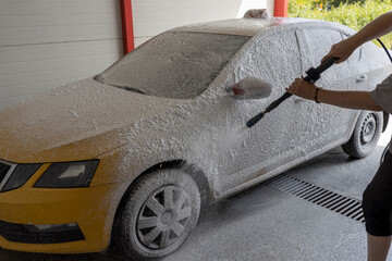 Taxi car in foam at a self-service car wash.