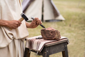 Craft, a man processes a stone with a hammer and a chisel, handicraft and art. Hobby concept,...