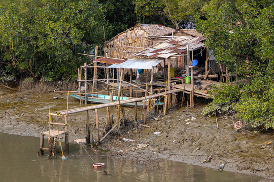 A simple house on a muddy riverbank.