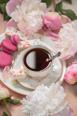 Cup of tea with sweet dessert and peony flowers