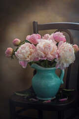 Bouquet of pink peonies in an old blue jug, retro style. Toned image