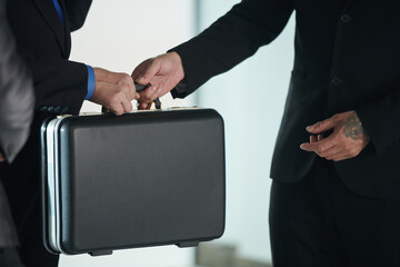 Cropped image of businessman giving briefcase with product or money to investor or business partner