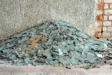 A pile of broken multicolored glass. Factory for recycling glass waste. The concept of renewable...