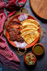 Homemade roti chapati flatbread on a rustic wooden board on a white wooden background