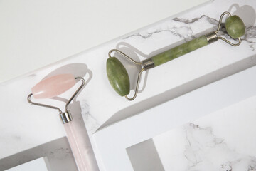 Rose quartz and jade facial roller for anti aging facial massage. Skin care luxury beauty tools.