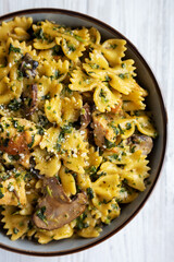 Homemade One-Pot Chicken and Mushroom Pasta in a Bowl on a white wooden background, top view. Flat lay, overhead, from above.