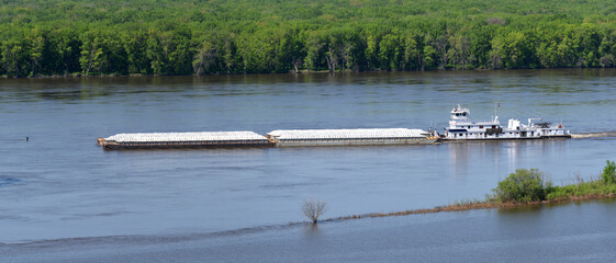Diesel powered barge moving  a set of hopper barges along the Mississippi river.