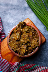 Beef meat stewed with potatoes and carrots in cast iron pan close-up view