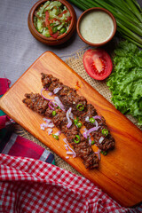 Barbecue chicken wings close up on wooden tray, shot with selective focus