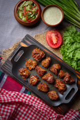 Barbecue chicken wings close up on wooden tray, shot with selective focus