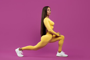 Beautiful young brunette woman stretching before exercise over purple background. Power and motivation concept.