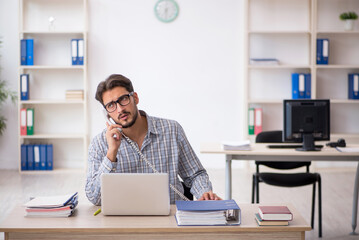 Young male employee sitting in the office