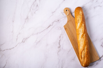 Freshly baked baguette isolated on light background, top view