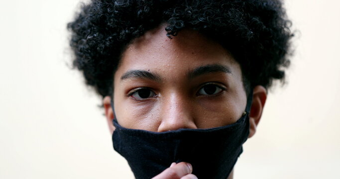 Young Boy Taking Off Covid Face Mask. Mixed Race Kid Removes Covid Mask