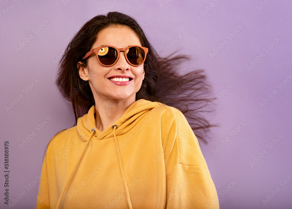 Canvas Prints relaxing toothy smiling woman moving the head and hair in action in yellow hoodie in summer sun glas